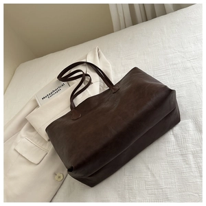 Dettaglio di una grande borsa tote caffè scuro in pelle PU lucida per il pendolarismo