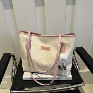 Pink and cream houndstooth large tote bag for women with plush doll charm on chair