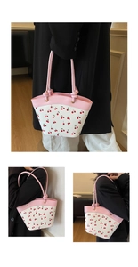 Close-up detail of cherry print pattern and pink leather trim on chic bucket bag