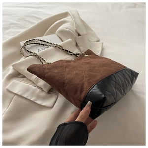 Détail du sac cabas rétro avec daim marron et cuir matelassé noir à motifs losanges