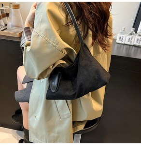 Detail shot of the black minimalist shoulder bag with decorative buckle and matte texture