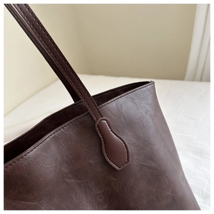 Dettaglio della trama in pelle marrone e delle cuciture di una borsa tote vintage
