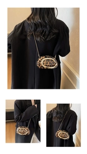 Detailed view of leopard print mini bag featuring a large gold C-shaped metal buckle