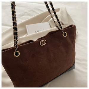Détail du sac cabas matelassé marron rétro avec texture mate et bandoulière chaîne dorée