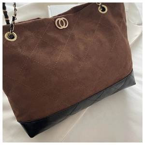 Détail du sac cabas matelassé en daim marron avec garnitures dorées et chaîne