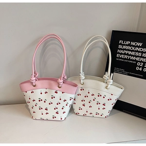 Detail of cherry print tote bags with knotted handles and scalloped edges in a minimal set