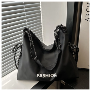 Détail d'un grand cabas noir tendance avec lettrage blanc et bandoulière en corde