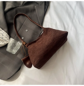 Detail of brown suede underarm bag with slim leather straps and matching mini coin purse