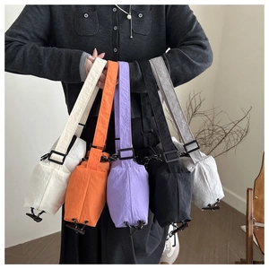 Detailed close-up of nylon crossbody bags in white, orange, purple, black, and grey
