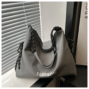Détail du cabas en nylon gris avec anses en corde tressée et lettrage fashion