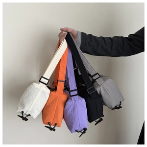 Détail de sacs bandoulière en nylon en blanc, orange, violet, noir et gris