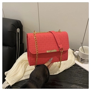 Close-up of rose pink woven texture shoulder bag with gold chain and metal lock