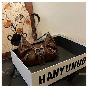 Close-up of retro dark brown patent leather shoulder bag with silver metallic buckle detail
