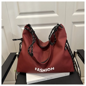 Détail du grand sac cabas rouge avec inscription fashion et bandoulière corde
