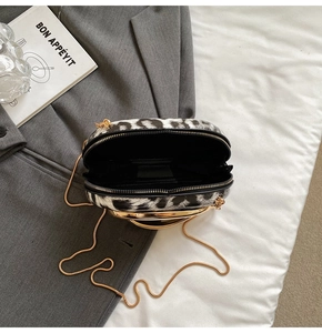 Macro view of leopard print bag interior with golden metal handle and snake chain