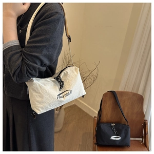 Détail du sac bandoulière en nylon avec sangle réglable et tirette de zip tissée