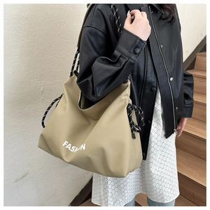 Détail du sac cabas en nylon beige avec cordons de serrage à pois noirs et blancs