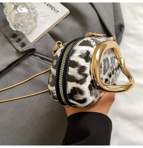 Detail of black and white leopard print crossbody bag with gold round metal handle