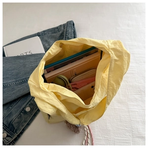 Top view of large yellow tote bag showing spacious interior with books and daily essentials