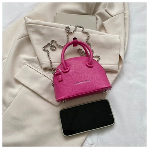 Detailed view of rose pink mini shell bag with litchi texture and silver ball chain
