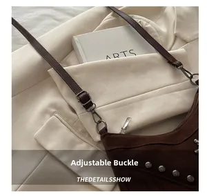 Close-up of adjustable strap buckle and fringe tassels on a vintage suede tote bag
