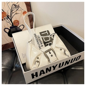 Detail of white glossy underarm bag with silver buckles in a stylish gift box