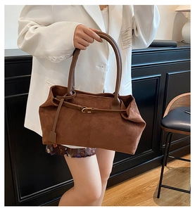 Detail of a large vintage brown faux suede tote bag with elegant metal buckle decoration