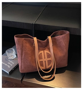 Detailed view of large vintage reddish brown suede tote bag with circular logo pattern