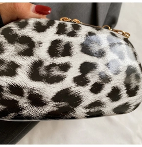 Detail of leopard print glossy mini bag with gold chain and polished finish
