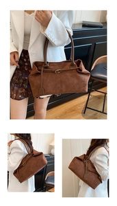 Detail of brown suede tote bag featuring decorative belt strap and gold buckle hardware