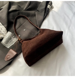 Close-up of deep brown suede shoulder bag texture with minimalist leather strap