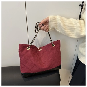 Détail d'un cabas en daim matelassé bordeaux avec bandoulière chaîne et boucles dorées
