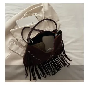 Detail showing inner capacity of dark brown suede fringe bag with metallic rivets