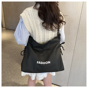 Detail of black large-capacity tote bag featuring FASHION print and rope straps