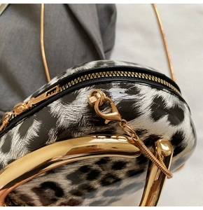 Close-up of leopard print handbag featuring glossy finish and gold metal chain handle
