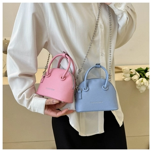 Close-up of mini lychee pattern shell bags in pink and blue with metal chain straps
