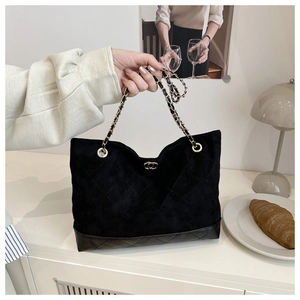 Gros plan du sac cabas en daim noir vintage avec cuir matelassé et bandoulière