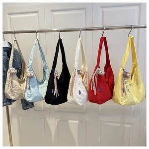 Detail of colorful nylon shoulder bags with gathered fabric and plush charm decorations