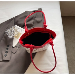 Detail of red cherry print tote bag with stylish knotted shoulder strap and PU leather