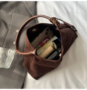 Detailed interior of brown suede tote bag showing magnetic closure and daily essentials