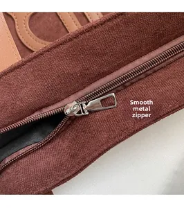 Detailed close-up of dark brown suede leather tote with a smooth silver metal zipper
