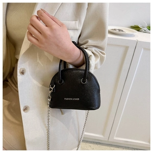 Close-up of litchi texture black shell bag with silver ball chain and logo detail