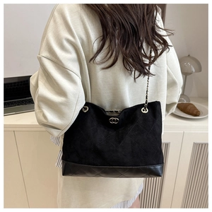 Détail du sac bandoulière matelassé noir avec chaîne en métal et tissu vintage texturé