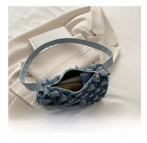 Detail showing the internal storage capacity of blue checkerboard denim crossbody bag