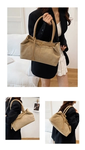 Detail view of khaki suede tote bag with slim shoulder straps and buckle accent