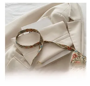Detail of vintage floral jacquard fabric and gold zipper on a stylish hobo shoulder bag