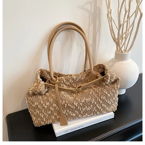 Close-up of khaki boucle fabric tote bag with brown leather handles and metal buckle