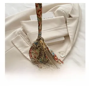 Detail of smooth gold metal zipper on floral linen shoulder bag with woven texture