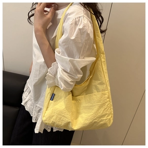Detailed view of a casual yellow canvas tote bag in Korean style worn by a model.