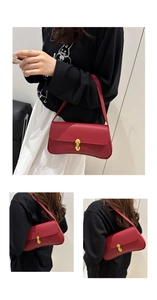 Close-up of red pebble leather baguette bag featuring a gold twist lock and fine texture